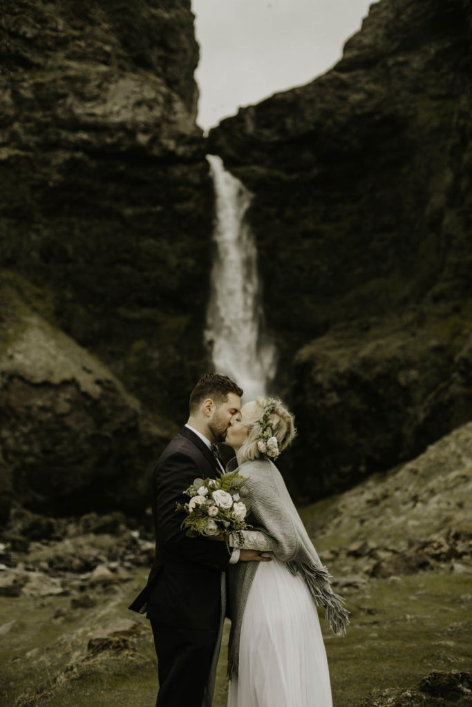 bride and groom at waterfall in Iceland