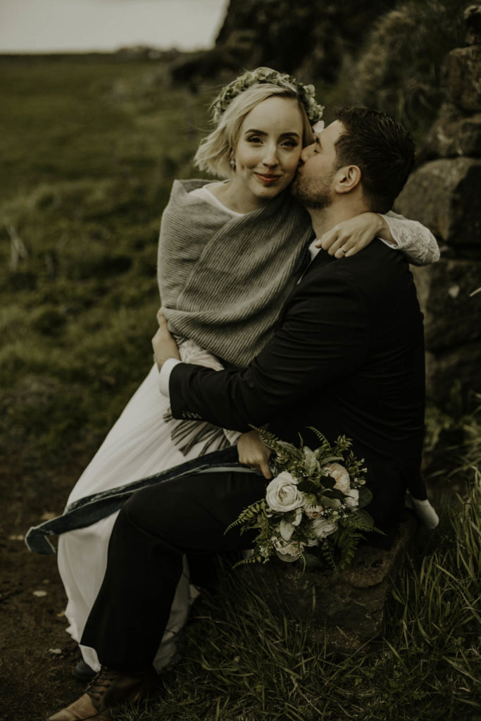 bride and groom in front of Icelandic home surrounded by mountains