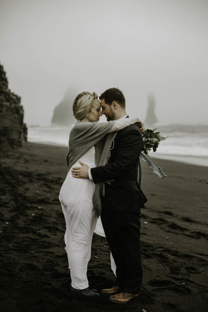 bride and groom on black sand beach