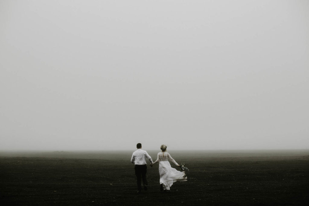 bride and groom running in fog