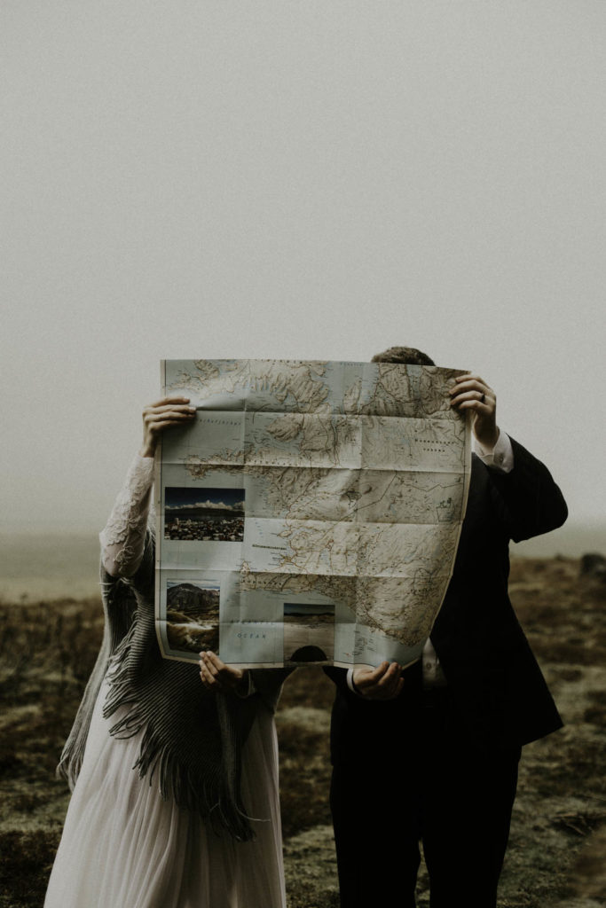 adventure bride and groom holding map of Iceland