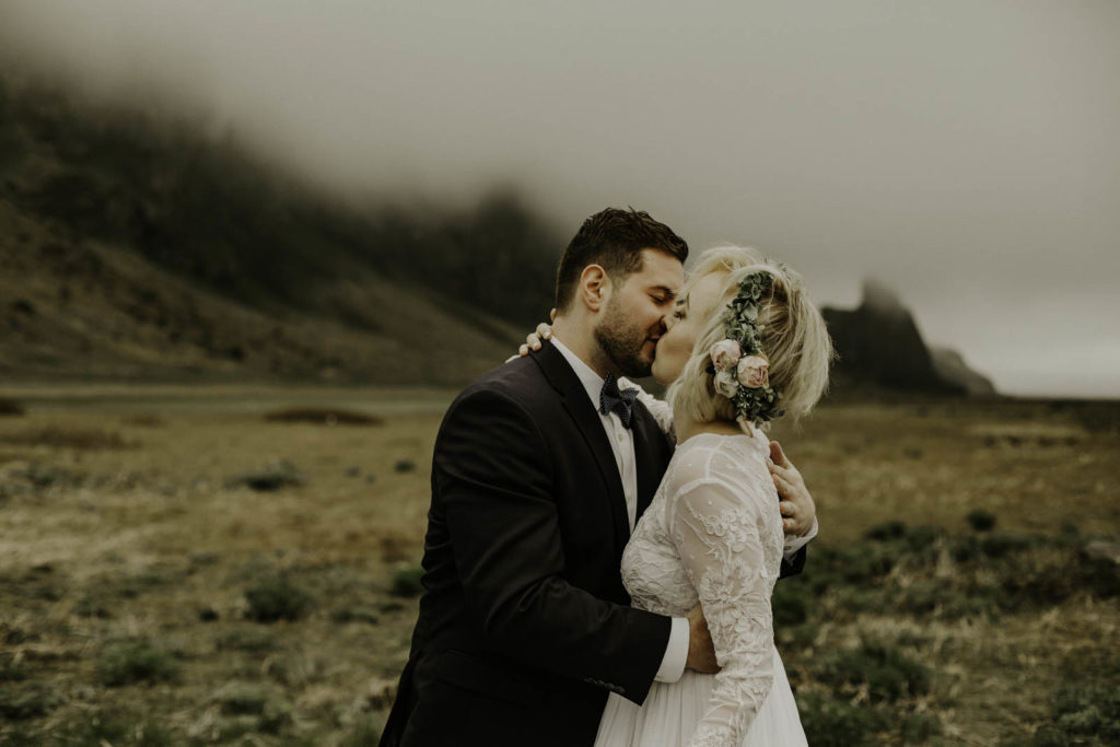 bride and groom surrounded by fog and Icelandic mountains