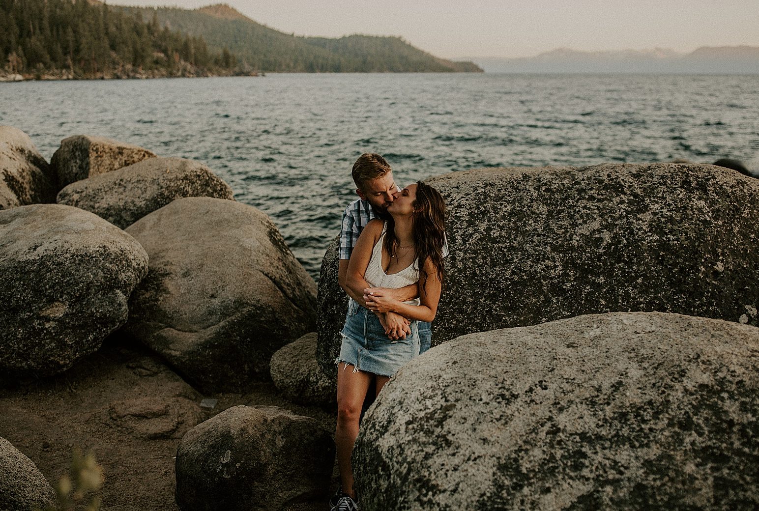 Lake Tahoe couple kissing in front of boulders