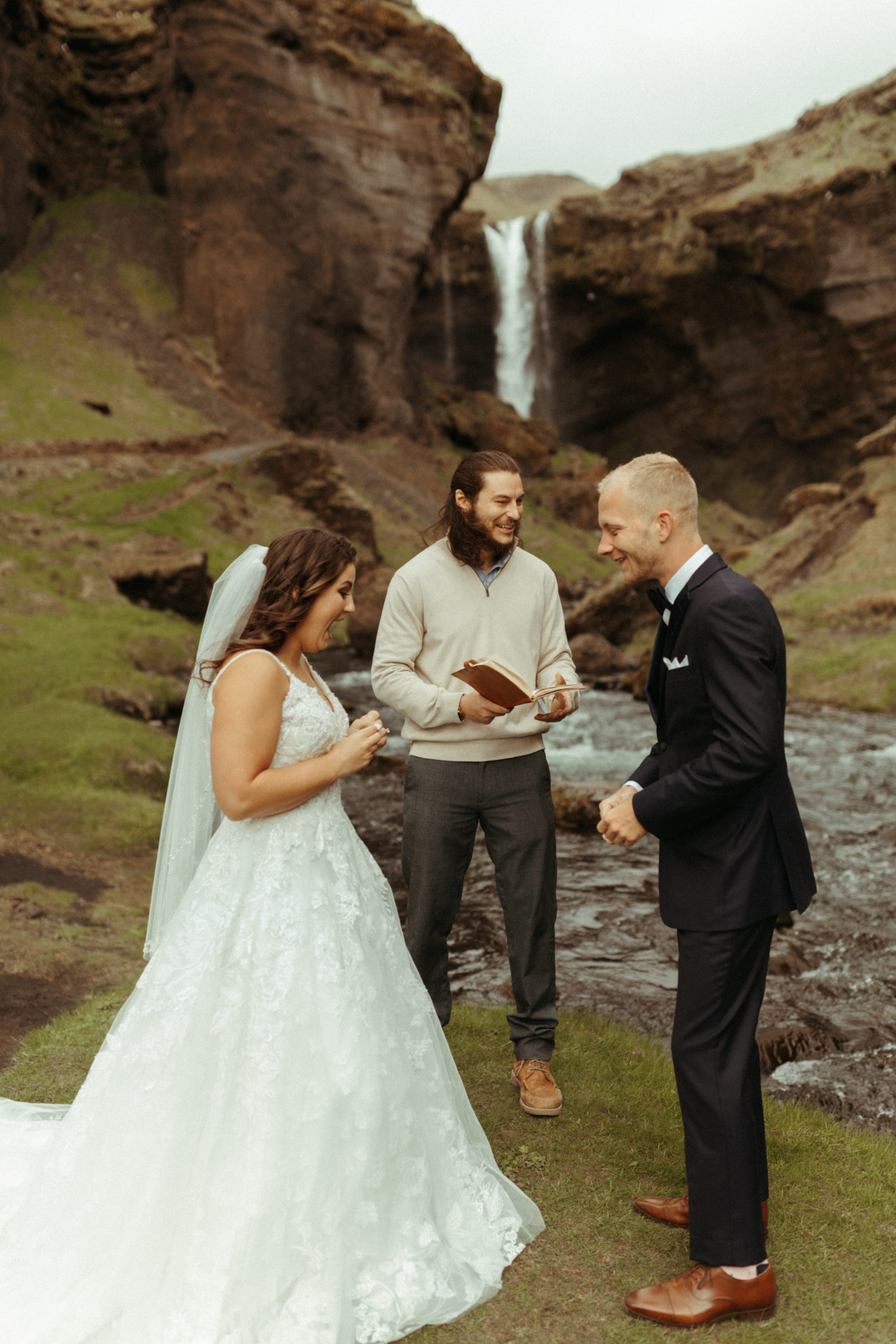 Iceland elopement in front of waterfall in green canyon with officiant.