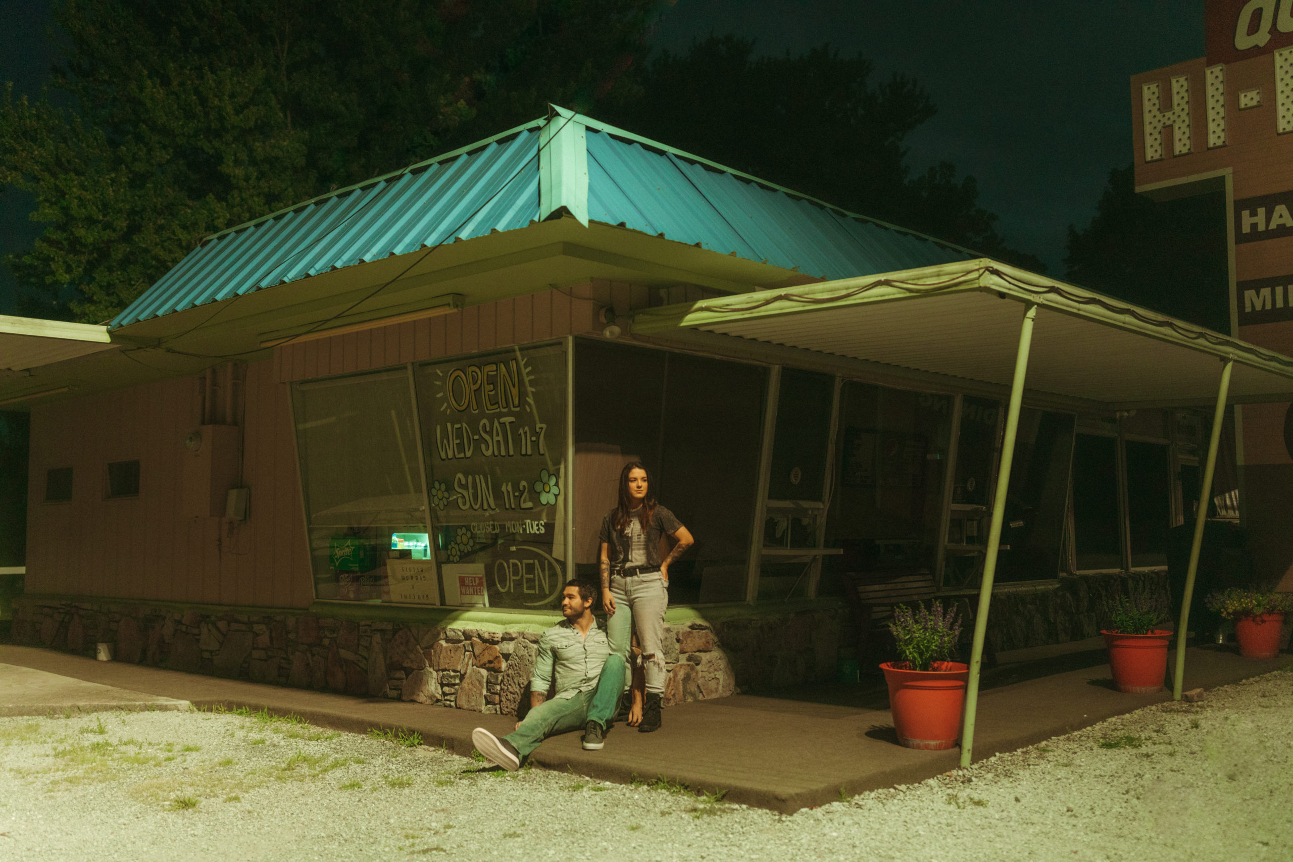 Cute couple standing outside an old vintage diner under the stars.