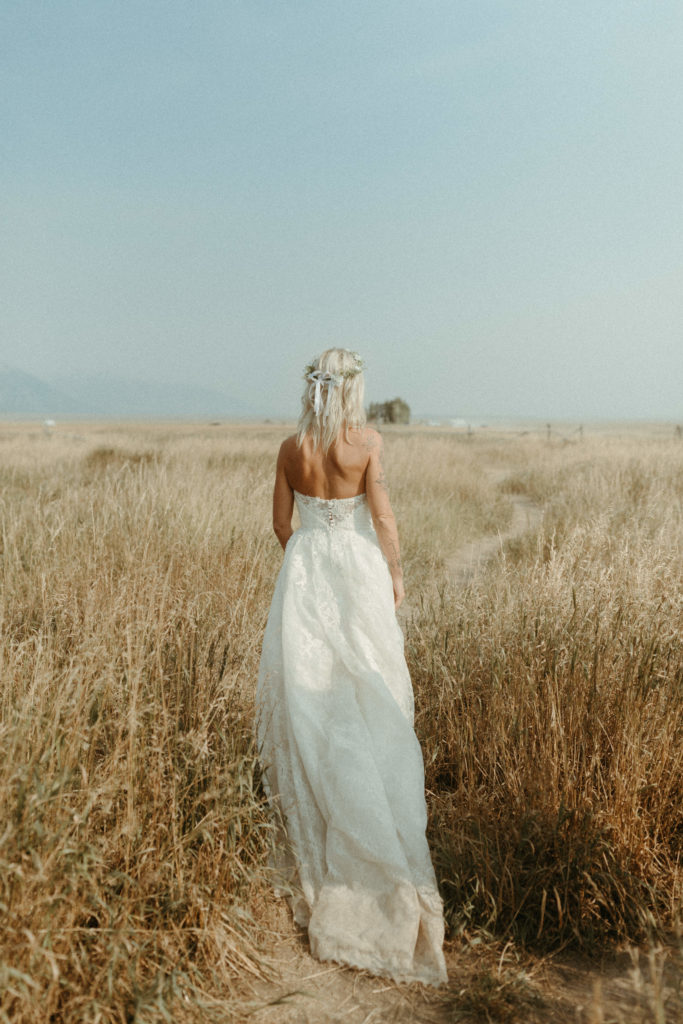 Bride walking through golden fields in national park wedding. 